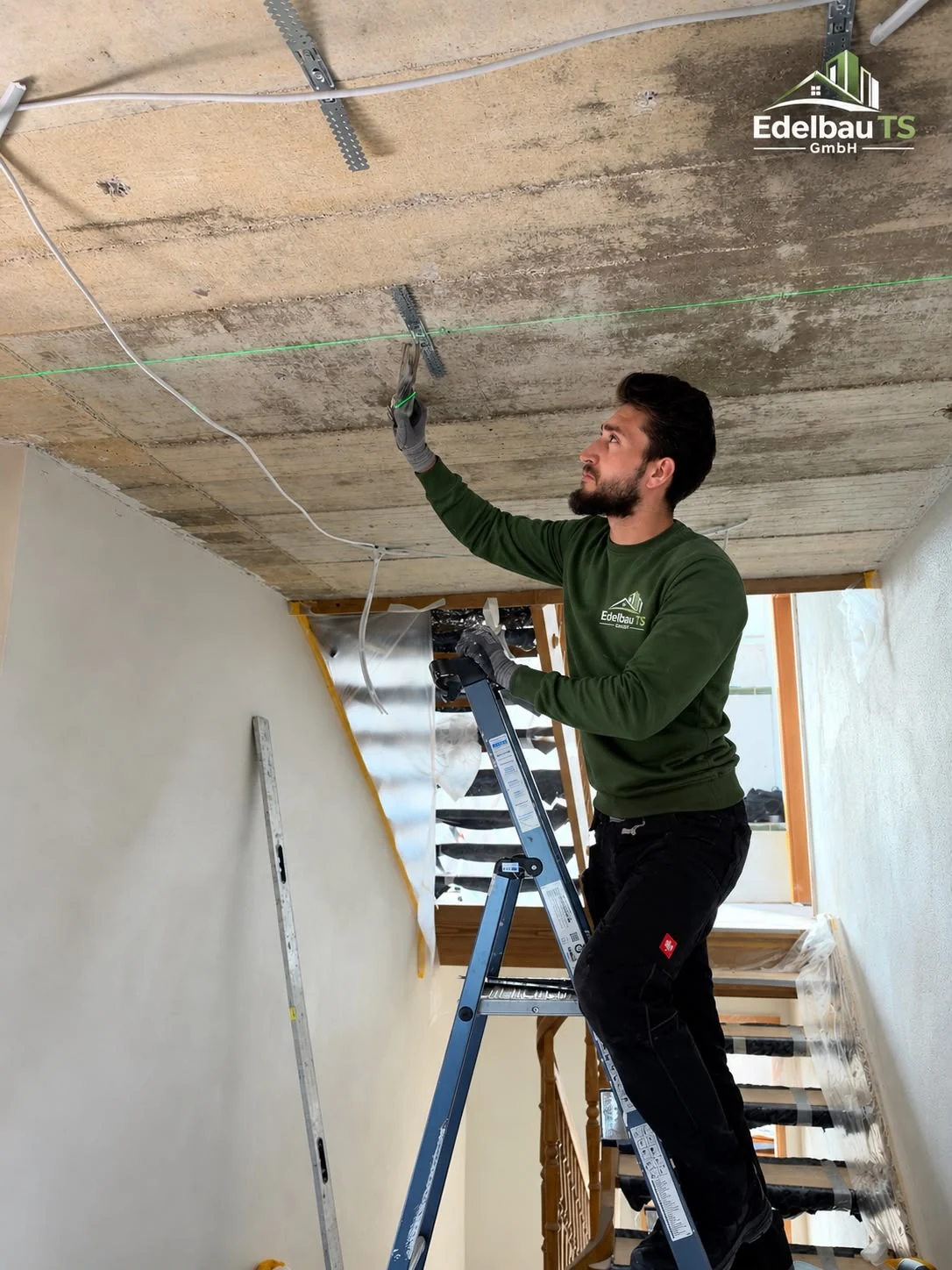 Ein Handwerker bei Arbeiten an der Deckenkonstruktion